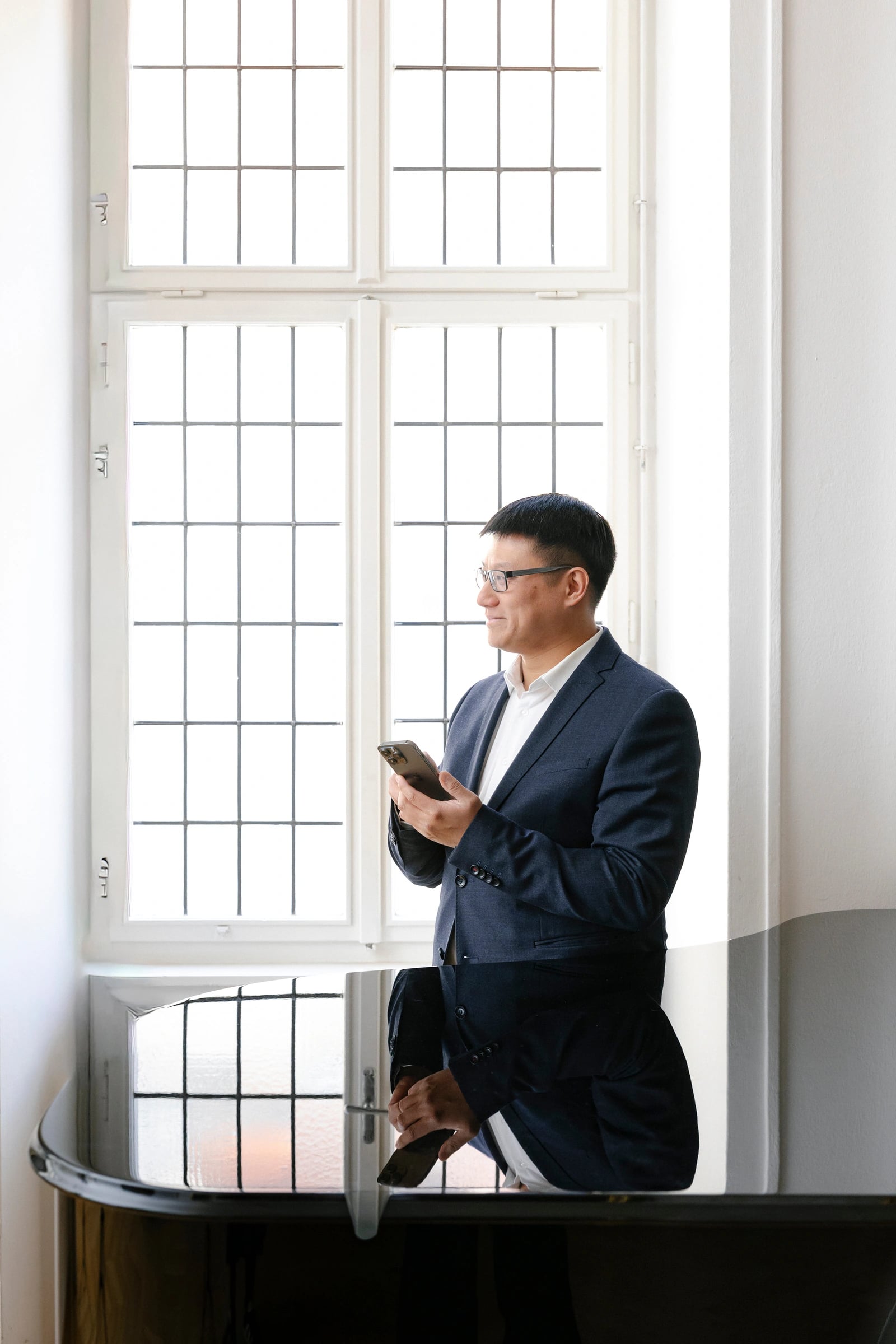 Wang-Yu Ko am Altbaufenster, den Blick nach draußen gerichtet